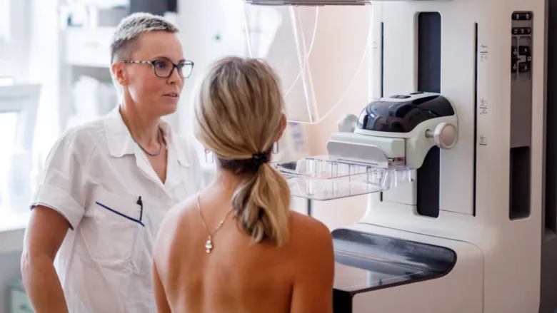 Lékařka vysvětluje pacientce postup mamografie.