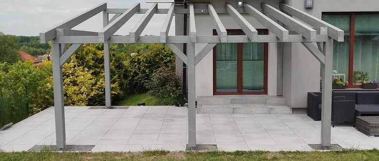 Nová dřevěná pergola na terase ukazuje spojení trámů bez viditelných hřebíků.