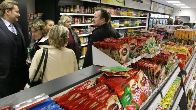 Lidé v obchodě s potravinami u regálů.