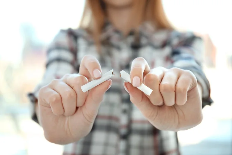 Ruce lámejí cigaretu na dvě části jako gesto přestání kouřit.