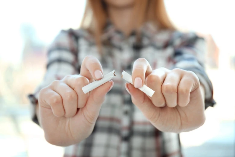 Žena láme cigaretu symbolizující přestání kouřit.