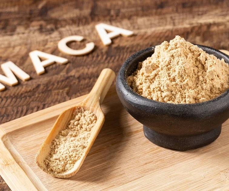 Dřevěná lžička s práškem z maky peruánské vedle malty.