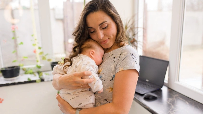 Mother holding baby while breastfeeding