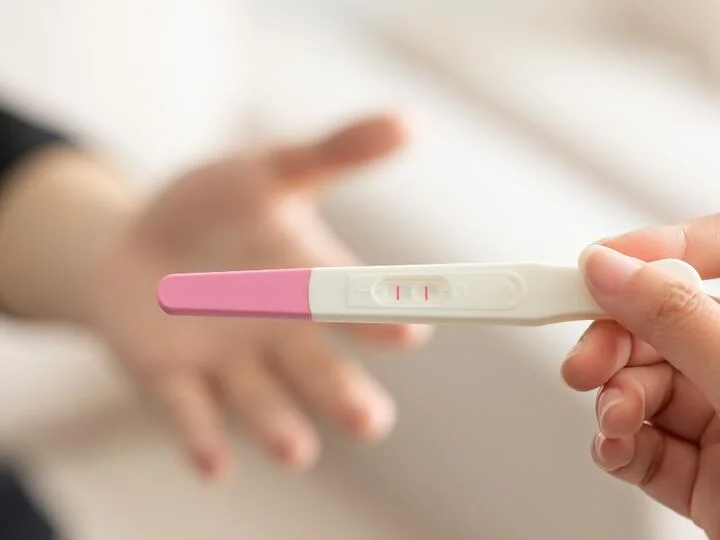 Těhotenský test s dvěma čarami v ruce