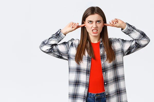 Woman plugging ears angry