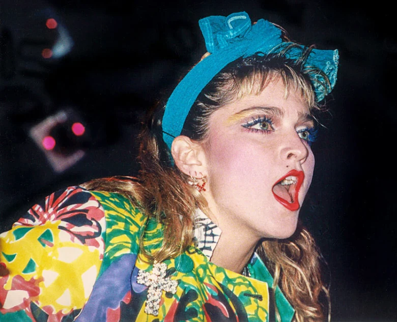 Madonna v barevném oblečení z osmdesátých let s modrou šátkem.