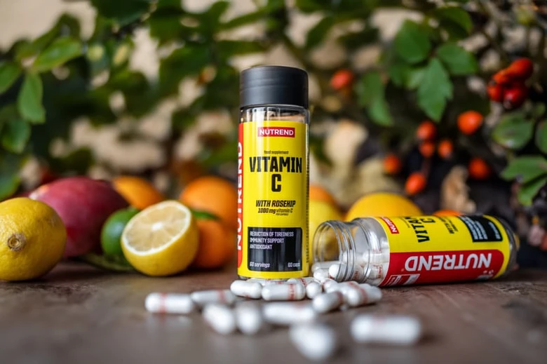 Fľaše s vitamínem C mezi čerstvými citrony a pomeranči.