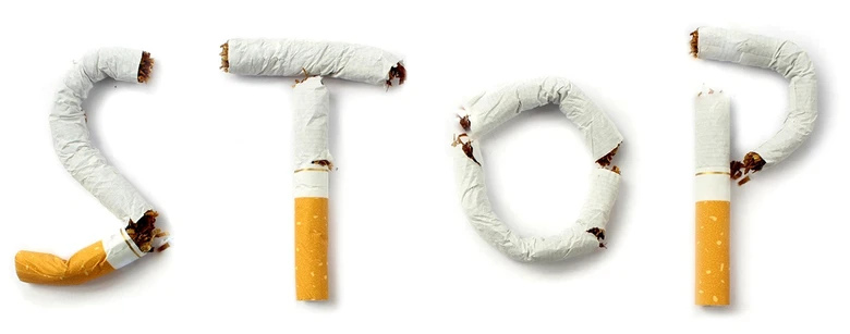 Kouřící cigarety tvoří slovo STOP na bílém pozadí.