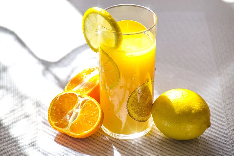 Sklenice s džusem z citrusových plodů doplněná o citron.
