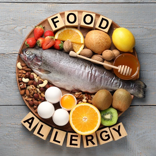 Různé alergenní potraviny na talíři s textem FOOD ALLERGY.
