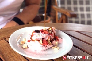 Bílé jogurt s jahodami a ořechy na stůl venku.