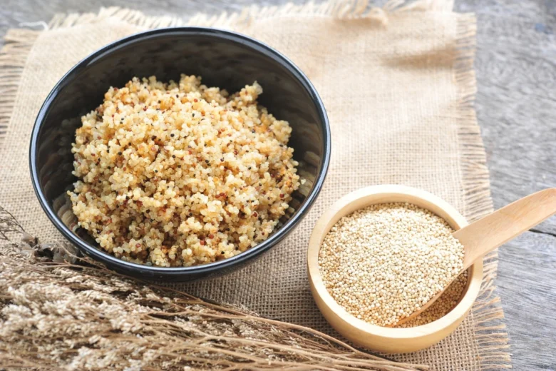 Uvařené a surové quinoa v miskách na plátně.