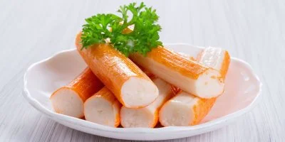 Surimi tyčinky na talíři s ozdobnou petrželkou