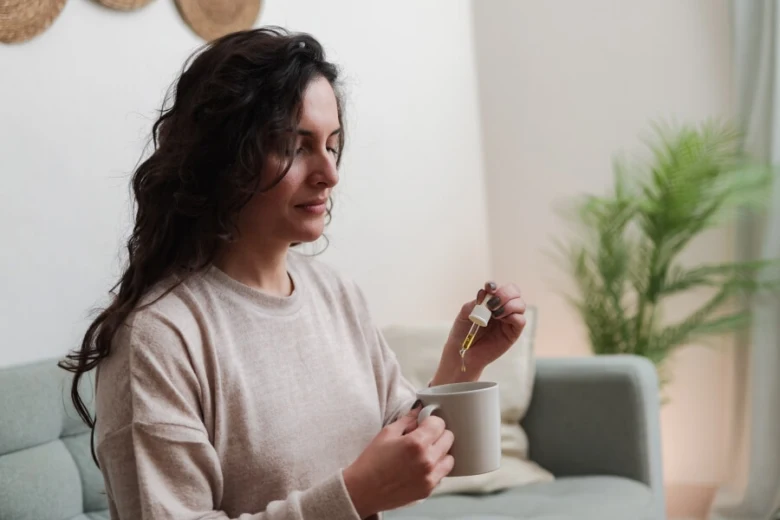 Žena s šálkem a kapátkem v domácnosti