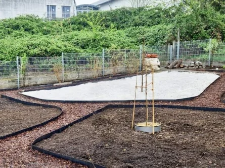 Příprava květinové louky na zahradě s mulčováním okrajů.