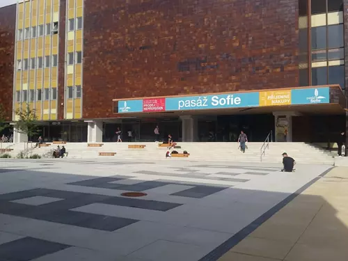 Nádraží v centru Sofie s lidmi na schodech před obchodním domem.