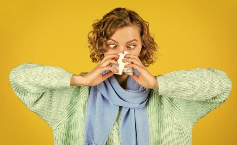 Woman sneezing with tissue