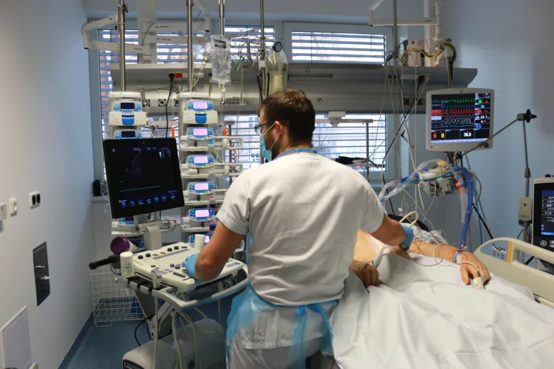 Lékař v nemocničním pokoji s pacientem na monitoru