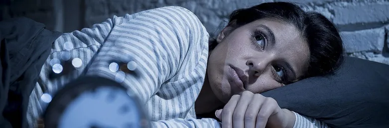 Woman lying in bed awake at night
