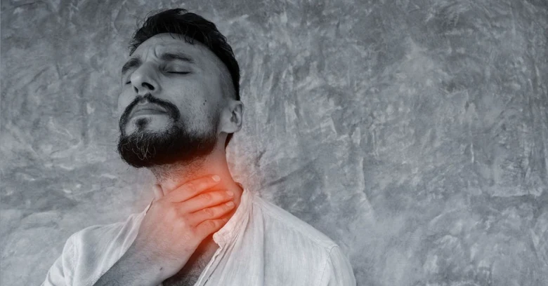 Muž drží hrdlo v bolesti při streptokokové infekci