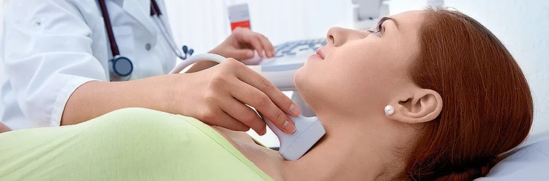 Lékař provádí ultrazvukové vyšetření štítné žlázy pacientovi.
