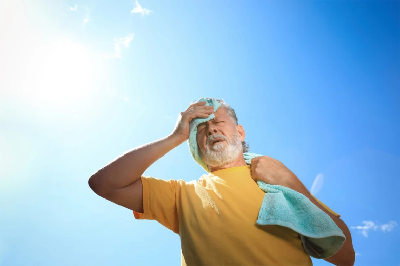 Man wiping sweat on forehead