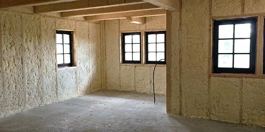 Nezhotovená místnost s PUR pěnovou izolací na stěnách a oknech.