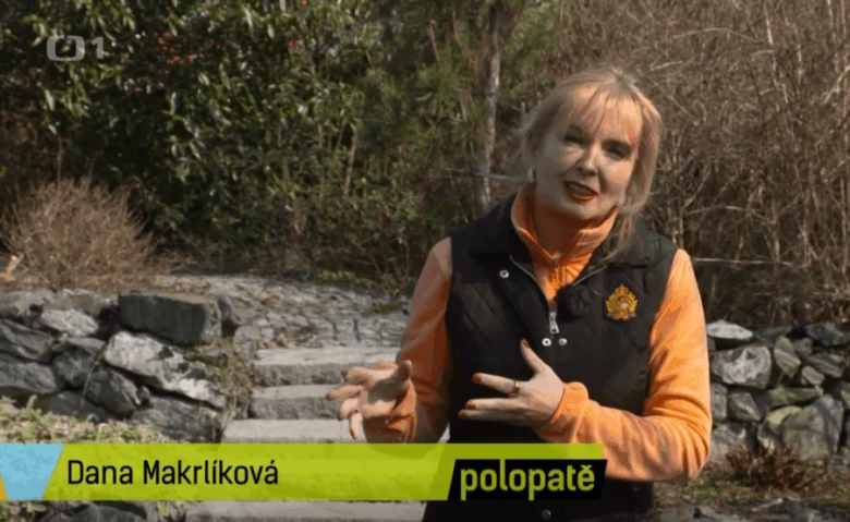 Žena vysvětluje pěstování skalníku v přírodním prostředí.