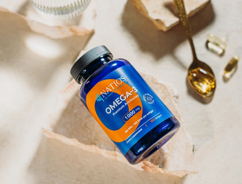Modrá lahvička s doplňkem stravy omega-3 vedle otevřené tobolky.