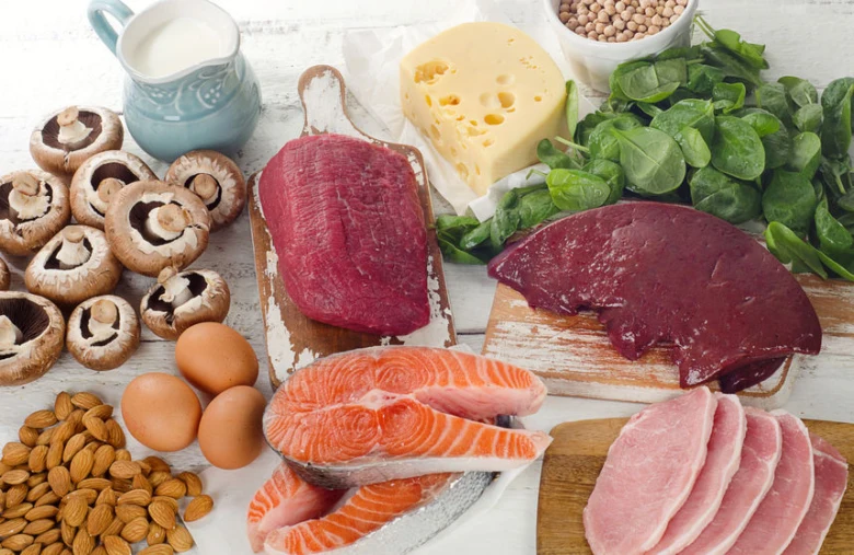 Různé potraviny bohaté na vitamíny skupiny B uspořádané na dřevěném povrchu.