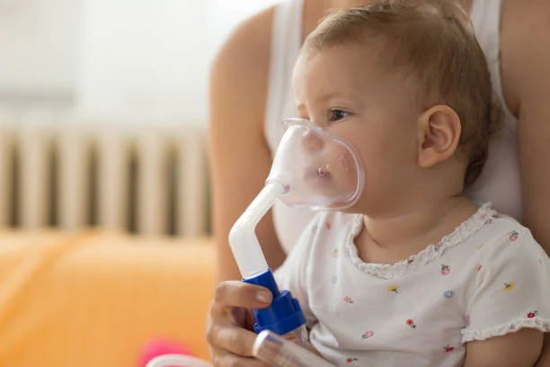 Dítě s maskou pro inhalační terapii při bronchitidě