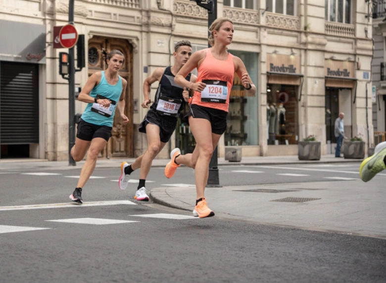 Ženy běží na půlmaratonu po městské ulici.