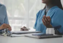 Dva lékaři v modrých uniformách diskutují o péči o pacienta.