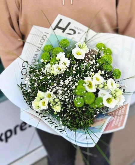 Květinová vazba s bílými květy a zelenou vegetací.