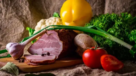Surové maso s čerstvými zeleninovými ingrediencemi na dřevěném prknu.