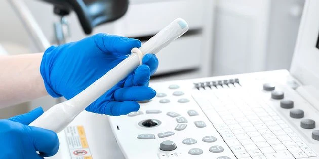 Sonografický senzor v rukou lékaře před diagnostickým zařízením.