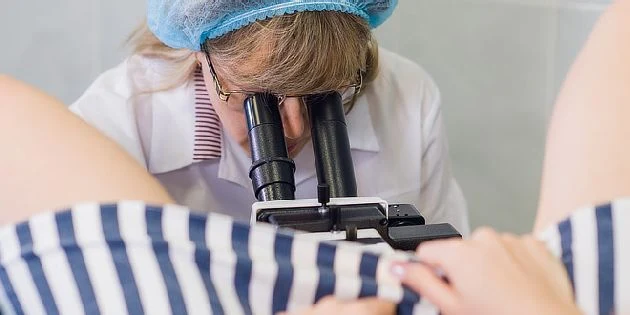 Gynekologka zkoumá děložní čípek pomocí kolposkopu.