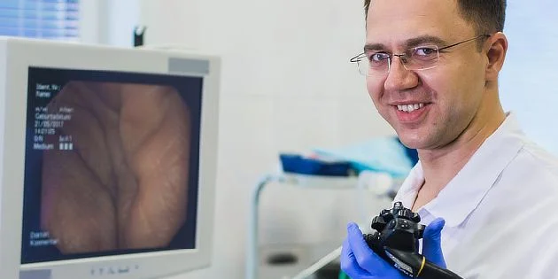 Lékař s endoskopem u monitoru zobrazujícího tlustý střevo.