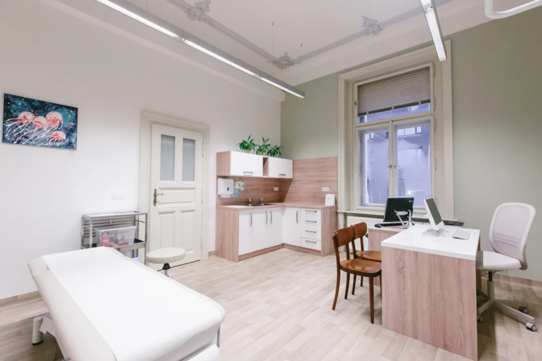 Moderní lékařský pokoj s lůžkem pro vyšetření pacienta.
